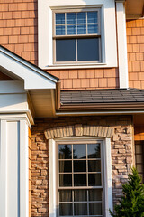 Fototapeta premium Luxury Home Exterior: Brick and Wood Design. Modern Architecture, Elegant Facade, and High-End Residential Property. Stunning Autumn Sunlight