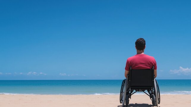 Man in Wheelchair Enjoying Beach View in Red Shirt Under Clear Blue Sky Reflecting Inclusivity Freedom and Summer Vibe in a Tranquil Coastal Setting Highlighting Accessibility and Serenity