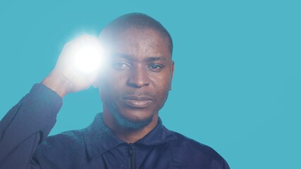 Headshot portrait of security employee tasked with evicting trespassers, turning on flashlight. Close up shot of patrolling agent using lantern, spotting intruders, studio background, camera A