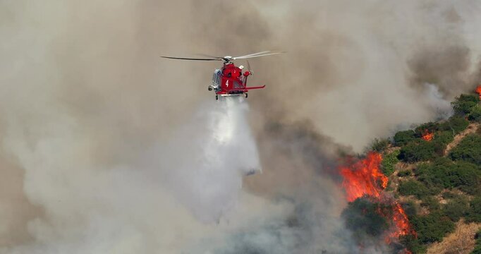 Firefighters are using helicopters to fight a wildfire in Malibu, Los Angeles, as thick smoke and flames threaten the nearby Pacific Palisades, raising safety and environmental concerns