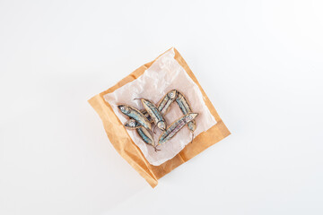 Hand-drawn fish illustrations on dried seed pods arranged on crumpled paper in a brown paper on a white background. Flat lay composition. Eco-friendly art and recycling concept. nature craft for kids,