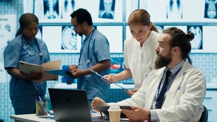 Healthcare experts in a treatment center analyzing x ray scans and test results in a meeting,...