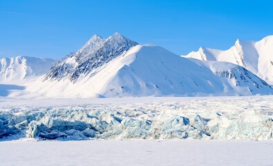 Fototapeta premium Glacier front of Fridtjovbreen and the frozen fjord Van Mijenfjorden. Landscape in Van Mijenfjorden National Park, (former Nordenskiold National Park), Island of Spitsbergen. Norway, Svalbard