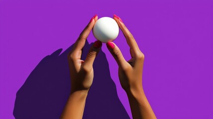 Hands holding a white ball against purple background artistic concept studio setting