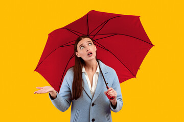 Rainy Day Concept. Portrait of beautiful young girl holding yellow umbrella, checking for rain,...