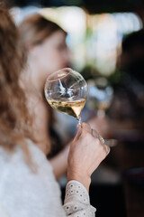 Close-up of a hand holding a wine glass at a sophisticated gathering, celebrating special moments