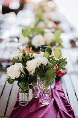 Elegant floral centerpiece with white roses and greenery on a table for a refined event setting