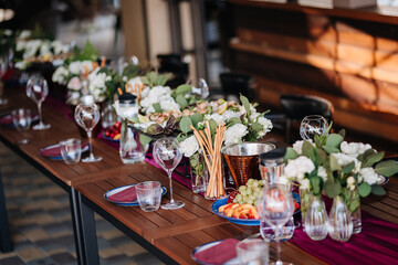 Elegant outdoor table setup with fresh fruit, flowers, and glassware for a festive gathering