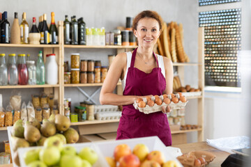 Female seller selling food products offers to buy chicken eggs