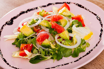 Vegan lunch meal plate with avocado, grapefruit, tomatoes and corn salad