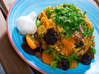 Traditional Central-Asian dish Pilaf - rice with spice, mutton, dried fruits and garlic