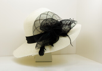 White straw women's hat with a black satin bow and veil