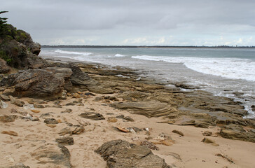 Sandy beach, rocky shoreline and the ocean at Point Lonsdale in Victoria, Australia
