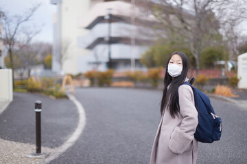 Fototapeta premium 冬の朝の住宅街で通学中の一人の小学生の女の子の姿