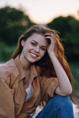 Naklejka premium Young woman smiling outdoors in casual attire, with long hair, showcasing happiness and warmth, perfect for lifestyle and beauty concepts.