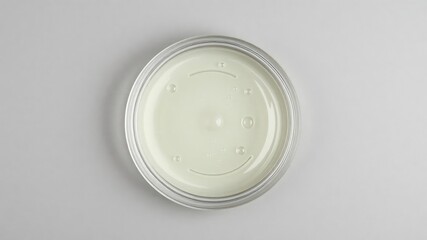 A petri dish with a ripple effect sitting on a grey background, innovation, technology