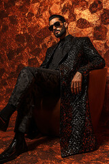 Naklejka premium Arab male in black geometric designs, leather footwear, styled waves