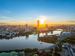 Fototapeta premium Yekaterinburg city and pond aerial panoramic view at summer or early autumn sunset. Night city in the early autumn or summer.