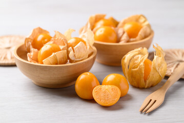 Cape gooseberry or Golden berry (Physalis peruviana) in wooden bowl on white background, Healthy fruit