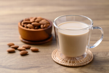 Almond milk in cup glass on wooden table, Alternative milk made from plant, non dairy