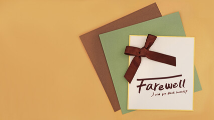 a farewell message card with a brown ribbon on brown and green kraft papers