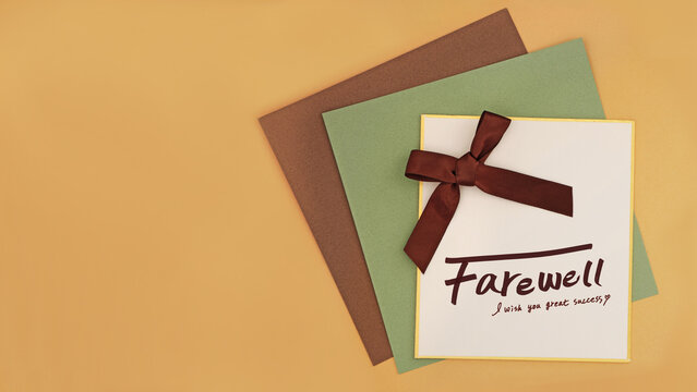 a farewell message card with a brown ribbon on brown and green kraft papers