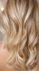 Naklejka premium Elegant and sophisticated close-up of a woman's styled loose curls in light blonde hair cascading down her back.