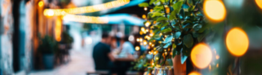 Charming outdoor cafe illuminated by fairy lights on a warm evening with blurred people dining nearby