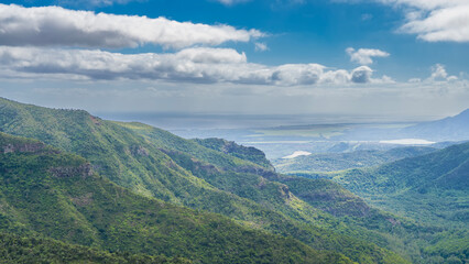 Beautiful mountain panorama. Green mountain slopes against a blue sky and clouds. In the distance,...