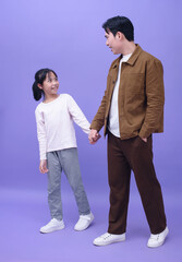 Young Asian father and daughter on purple background