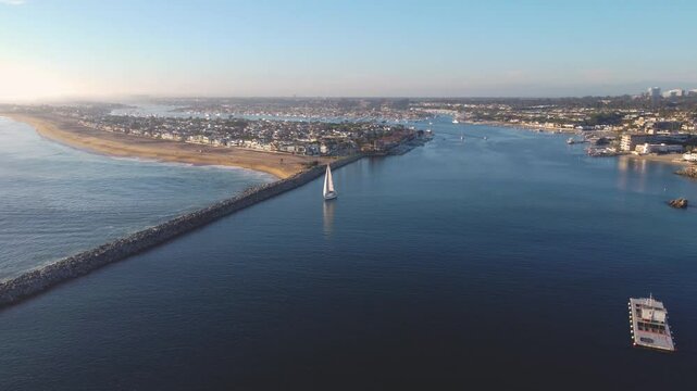 Balboa Peninsula Pan Past - Jetty Canal, Port Harbor Bay Entrance - to Newport Beach, Orange County, Southern California Coast, USA. Corona Del Mar. Mountian View City Skyline on Hillside