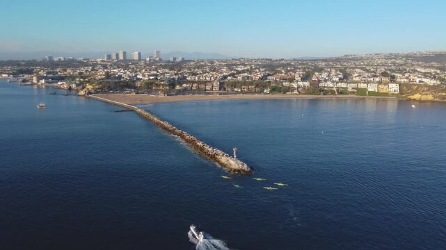 Balboa Peninsula Pan Past - Jetty Canal, Port Harbor Bay Entrance - to Newport Beach, Orange County, Southern California Coast, USA. Corona Del Mar. Mountian View City Skyline on Hillside