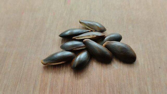 Sapodilla seeds are black with a wooden background