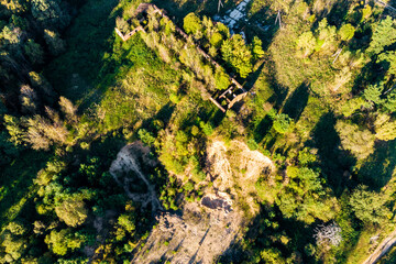 Unused sand quarry next to ruins of abandoned farm, aerial view