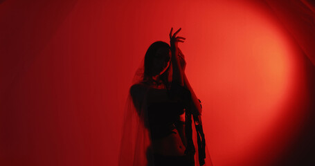 Female dance. Movement therapy. Relaxed woman silhouette in trance wearing polyethylene rags...