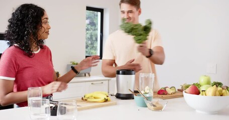 Preparing healthy smoothies, young multiracial couple chopping fruits and vegetables, at home