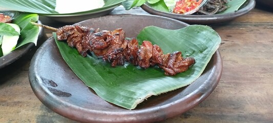 Very delicious chicken skin satay on banana leaves
