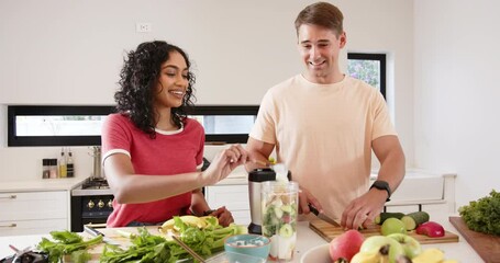 Preparing healthy smoothie, young multiracial couple chopping fruits and vegetables, at home
