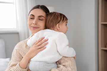 Young mother hugging her baby at home. International Hug Day