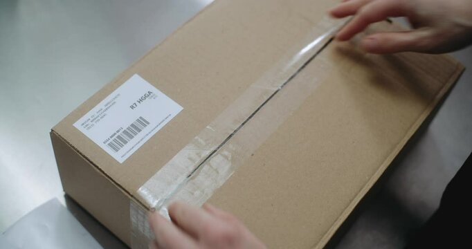 Close Up of Warehouse Clerk, Postal Worker Putting Sticker on Package with Online Orders, Scanning Code, Preparing for Shipping to Customers. Sorting Center of E-Commerce Store, Delivery Service.