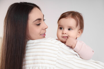 Young mother holding her baby at home, closeup