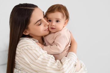 Young mother hugging her baby at home. International Hug Day