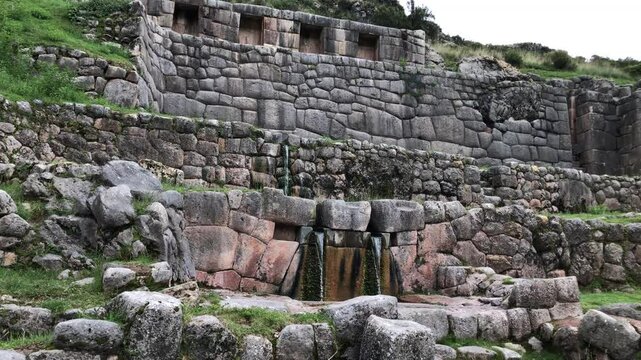 Water flows from ancient inca stonework at tambomachay near cusco, peru
