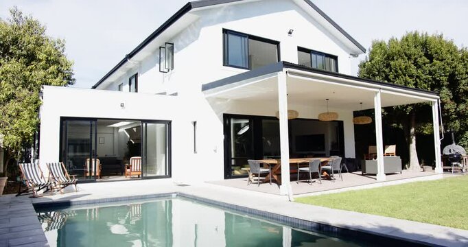 Modern house with swimming pool and outdoor dining area in backyard