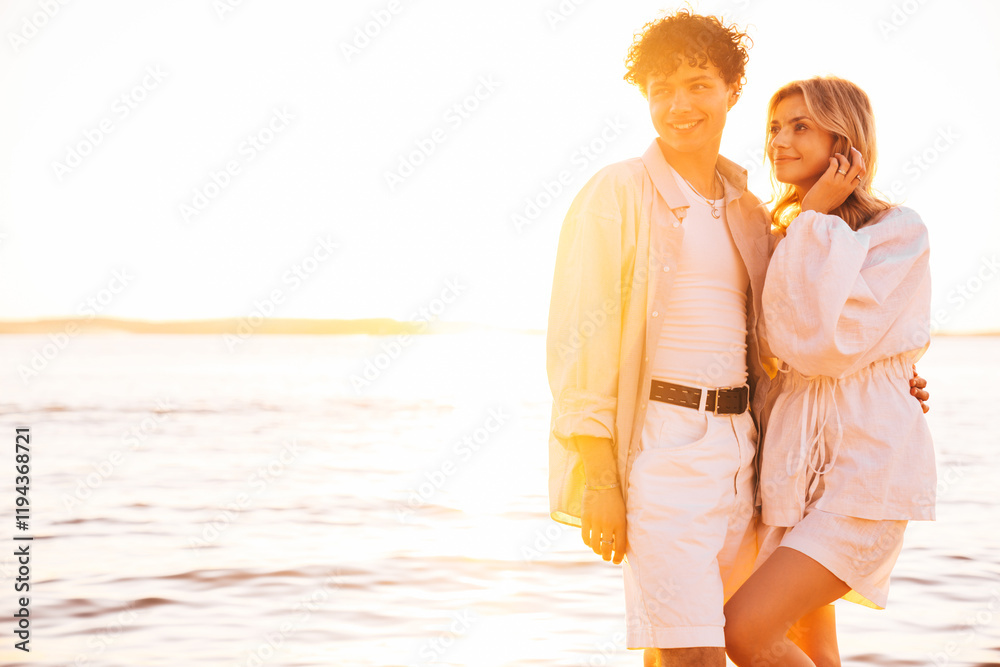 Poster Smiling beautiful woman and her handsome boyfriend. Excited couple in casual clothes. Happy cheerful family. Female and man pose at sunrise over sea beach outdoors. Seaside in summer day