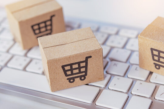 Shopping online. Cardboard box with a shopping cart logo on laptop keyboard. Shopping service on The online web. offers home delivery