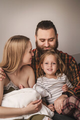 Happy family meets new baby. Mom, dad, older daughter and newborn son. Parents introduce older sister to baby
