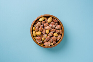 Top view of salted peanuts in wooden bowl