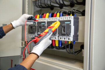 Checking the electrical system, an electrician is using an electric meter to check the electrical...
