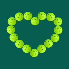 Heart shaped pattern made of green pickleballs balls on transparent background.